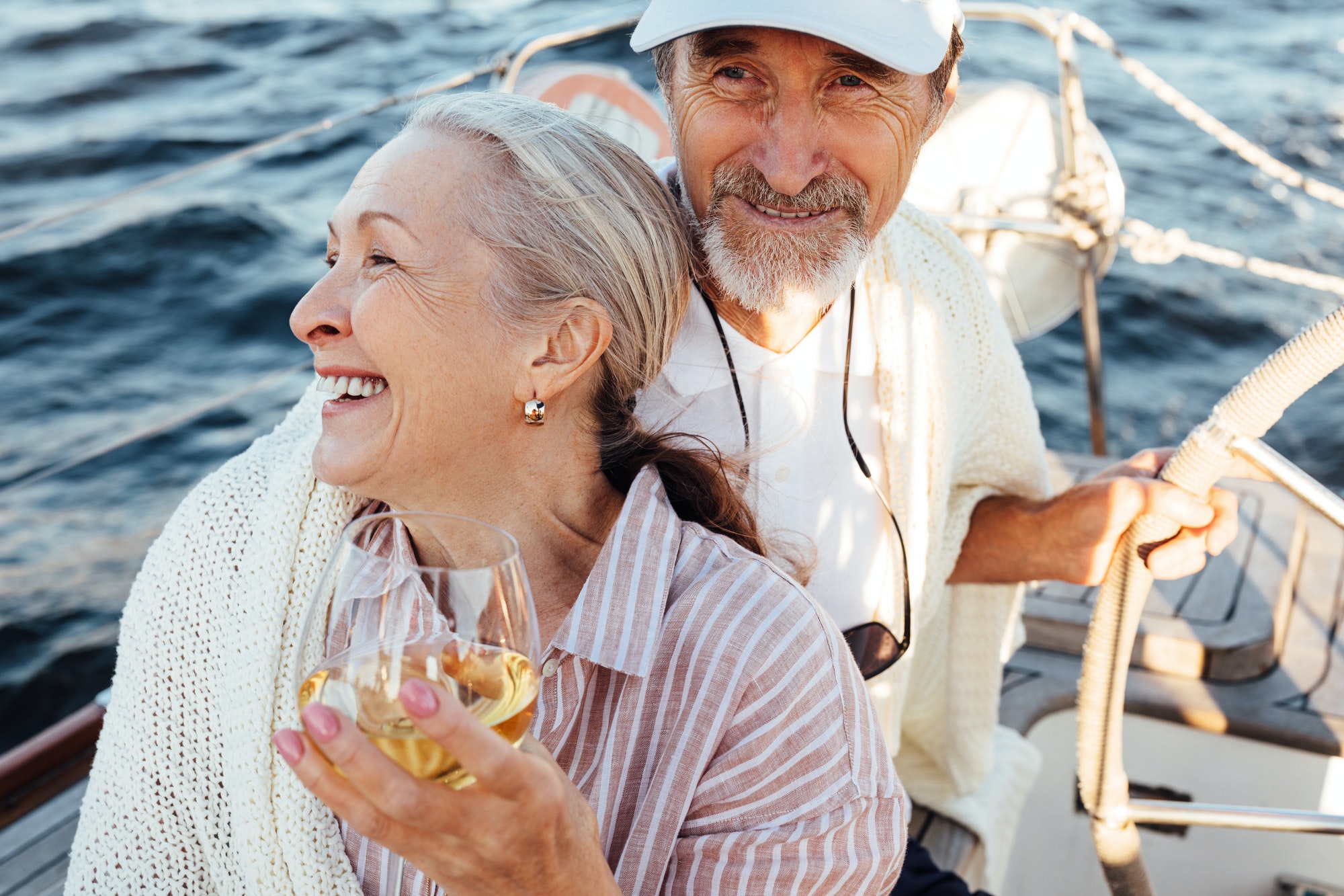 Smiling elderly couple enjoying vacation on a private yacht