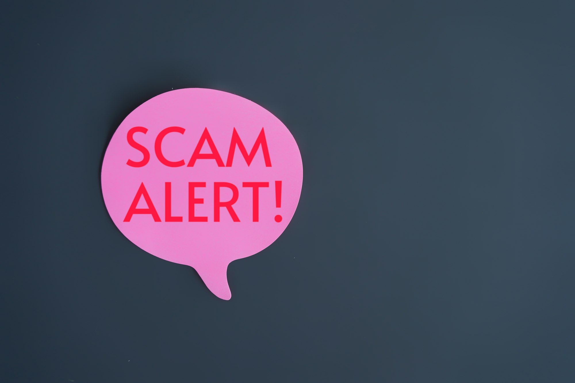 Top view image of speech bubble with text SCAM ALERT!.